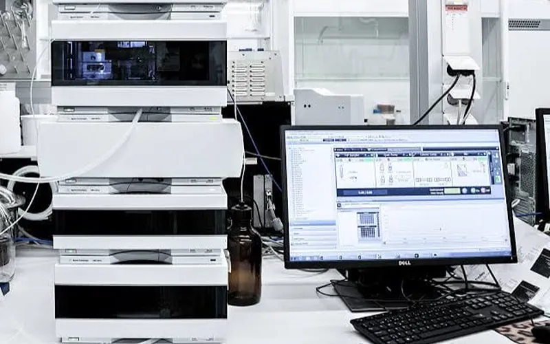 Instrumen analisis laboratorium di samping monitor hasil uji